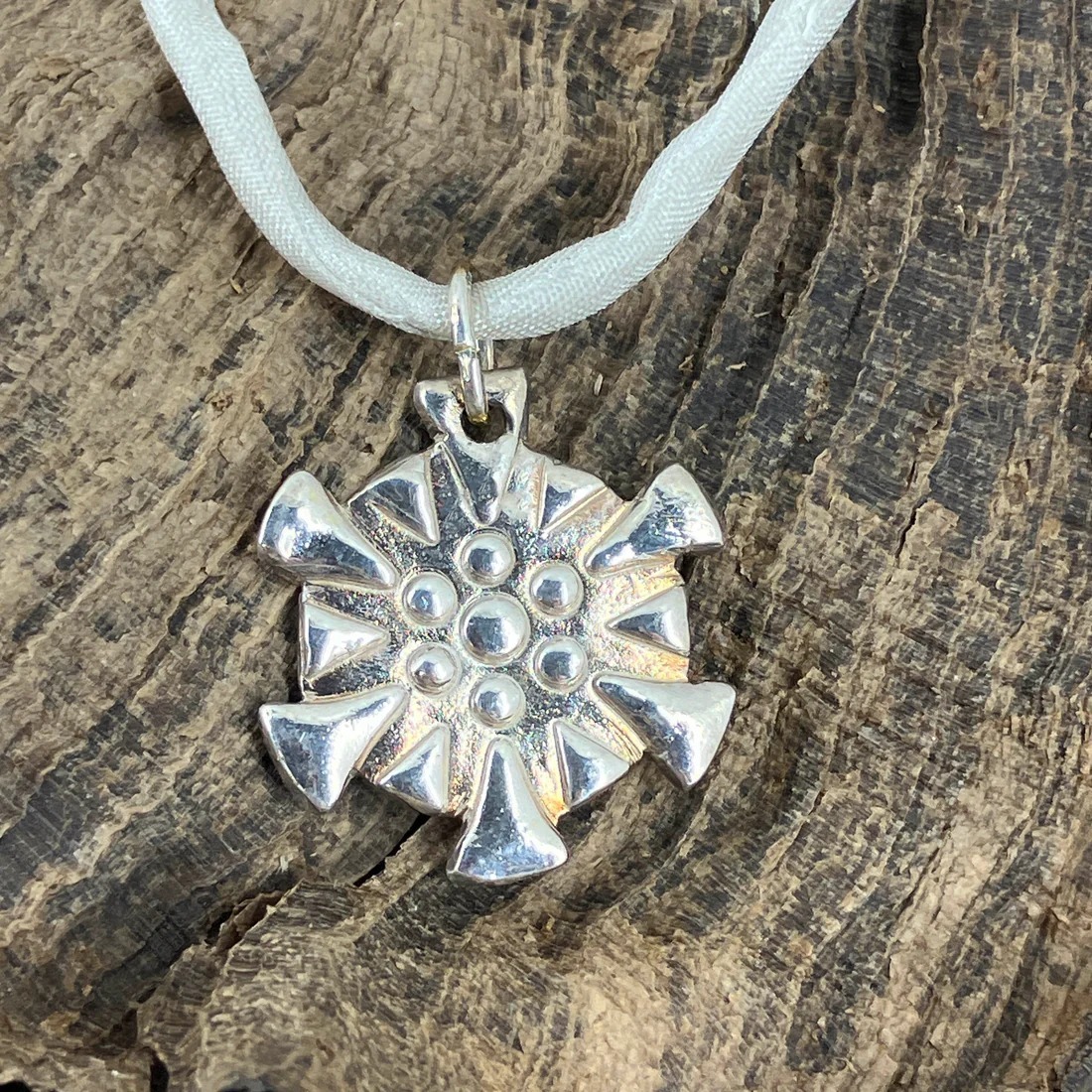 Snowflakes falling caught on a pendant with a fine silk necklace