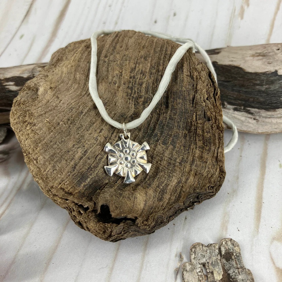 Snowflakes falling caught on a pendant with a fine silk necklace