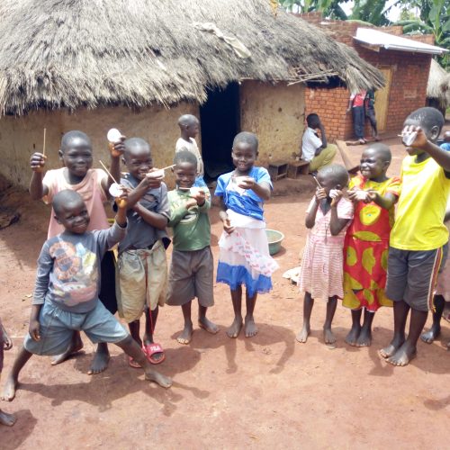 Children possing with their stool samples picked for examination during deworming campaigne in Olyeko-ambe in, Papoga Parish, Zeu Sub county, Zombo District.