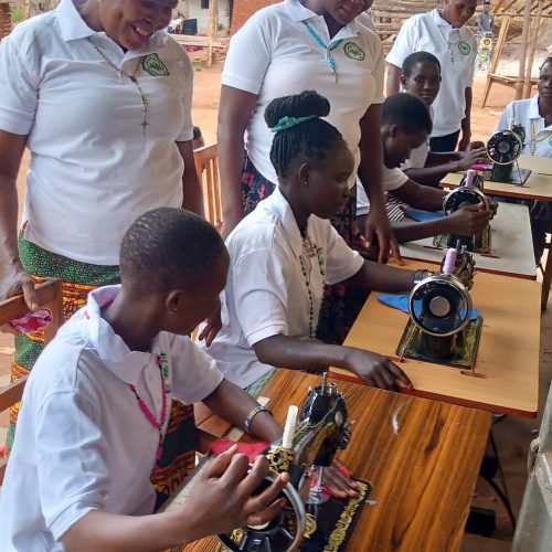 Trainers monitoring the school drop out how they are picking up their skills in sewing the different fabric.